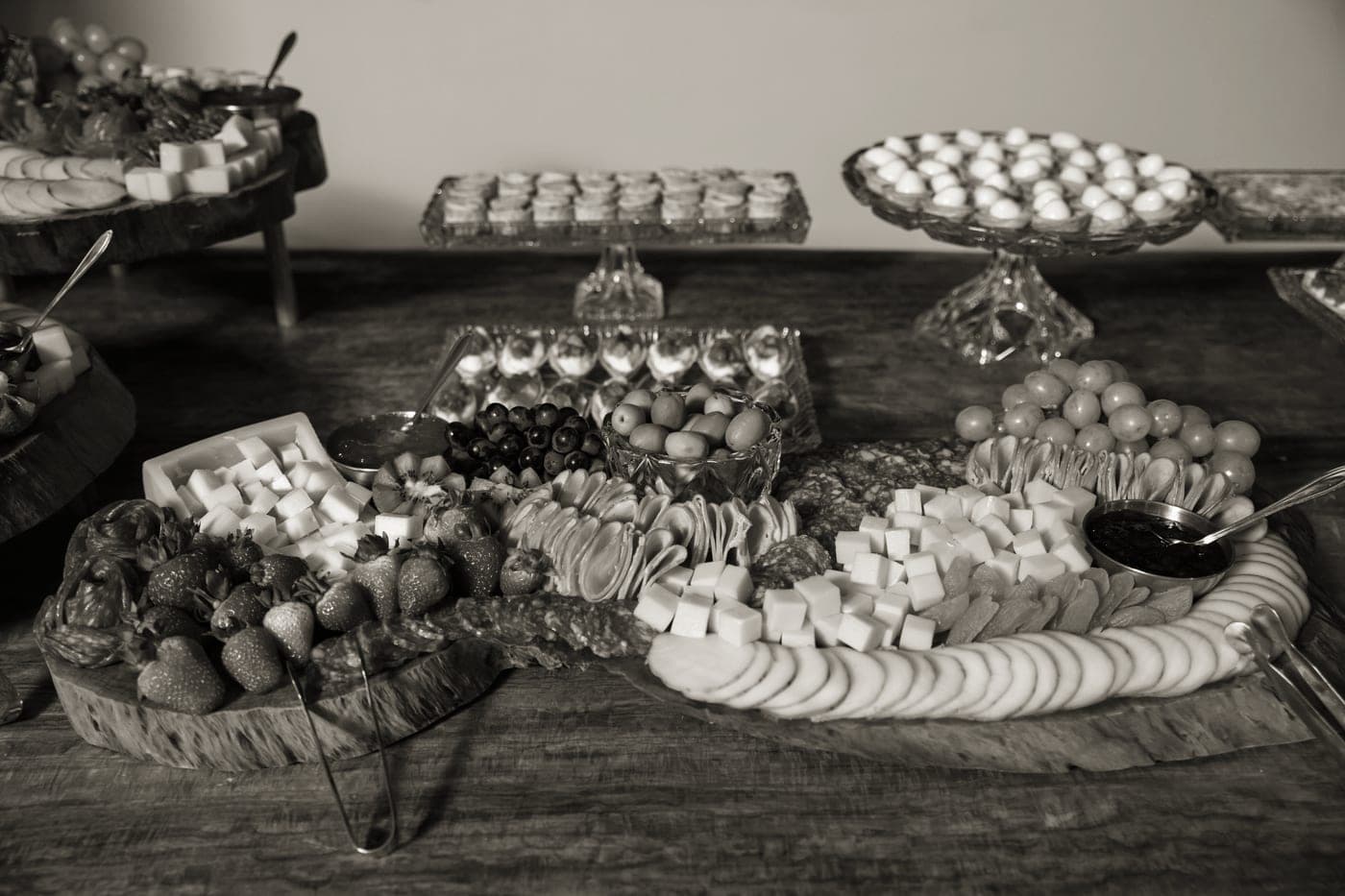A charcuterie board of cheeses, cured meats and grapes on a rustic wooden table