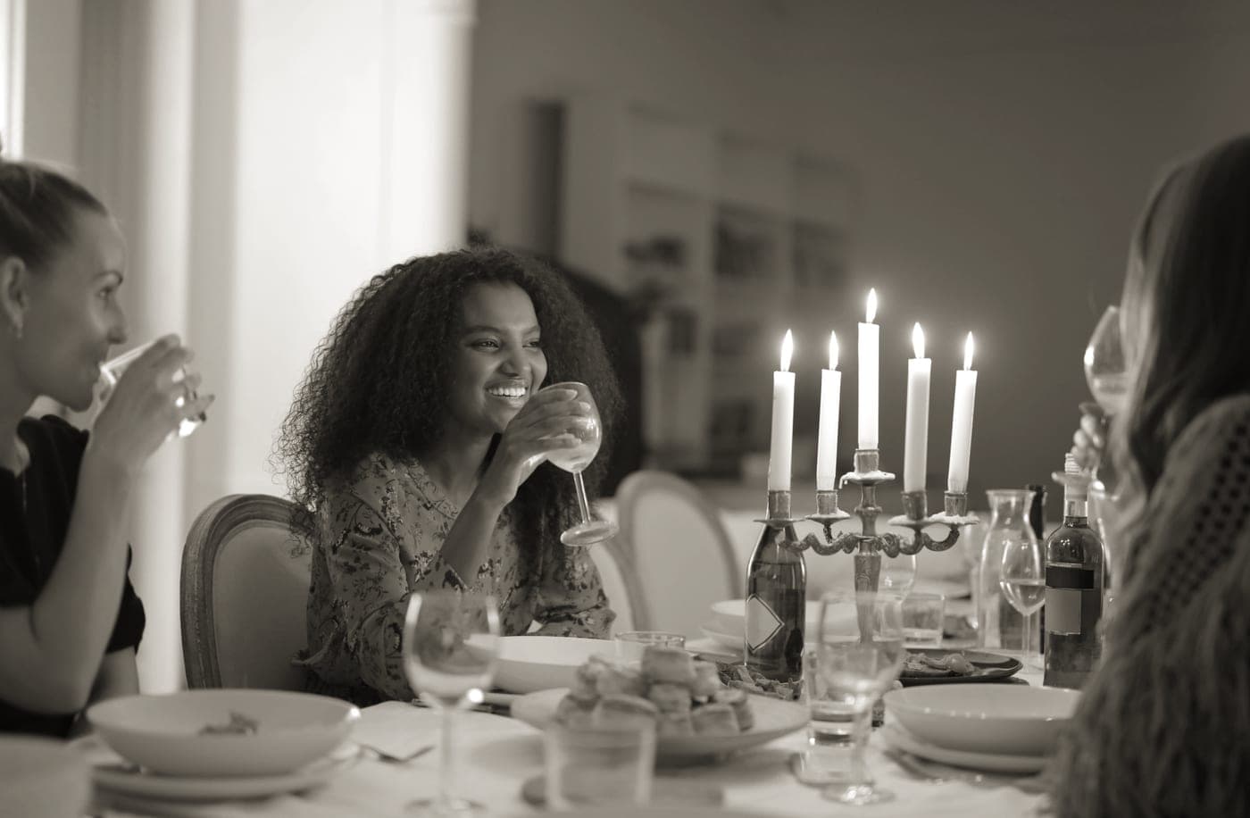 Friends around a dinner table with candles in the evening